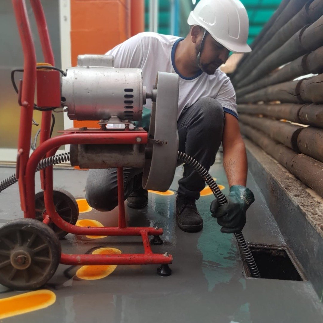 Técnico profissional realizando desentupimento com equipamento moderno